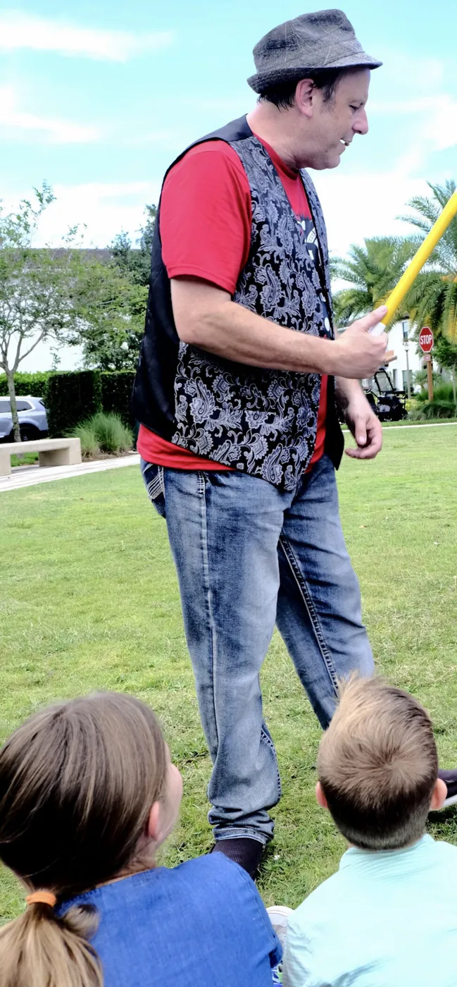 Eric The Magic Guy with a magic wand, performing for kids at an outdoor birthday party